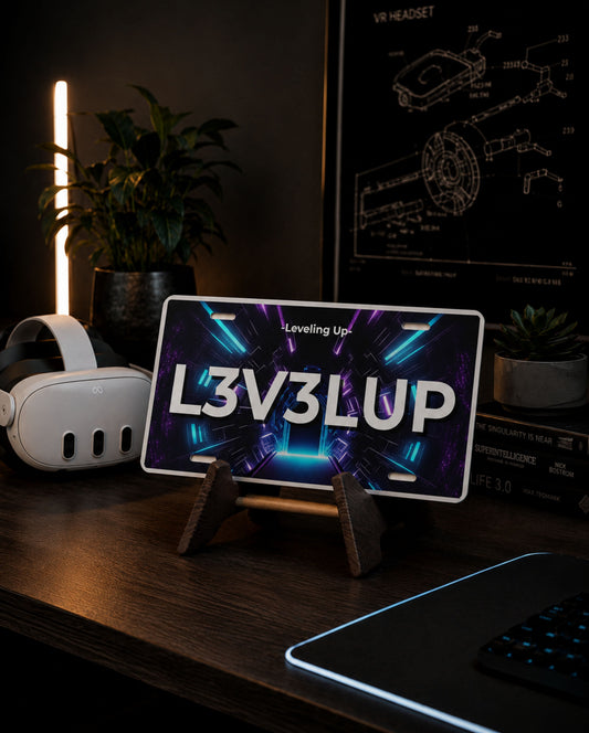 A smartphone on a small wooden stand displaying the text 'L3V3LUP' and 'Leveling Up' over a neon tunnel graphic, set on a dark desk with a VR headset, plants, and a framed technical drawing in the background.